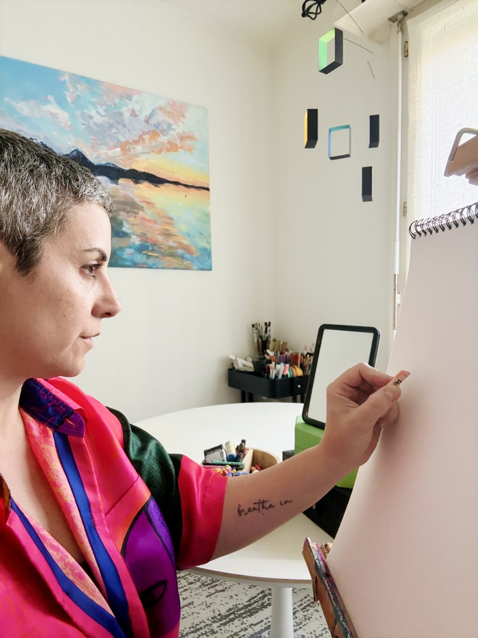 Sonia Giron drawing a self-portrait on canvas while looking at herself in a mirror