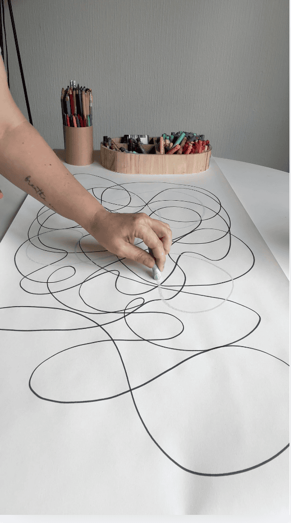 A person practising breathwork and meditative art with pastels