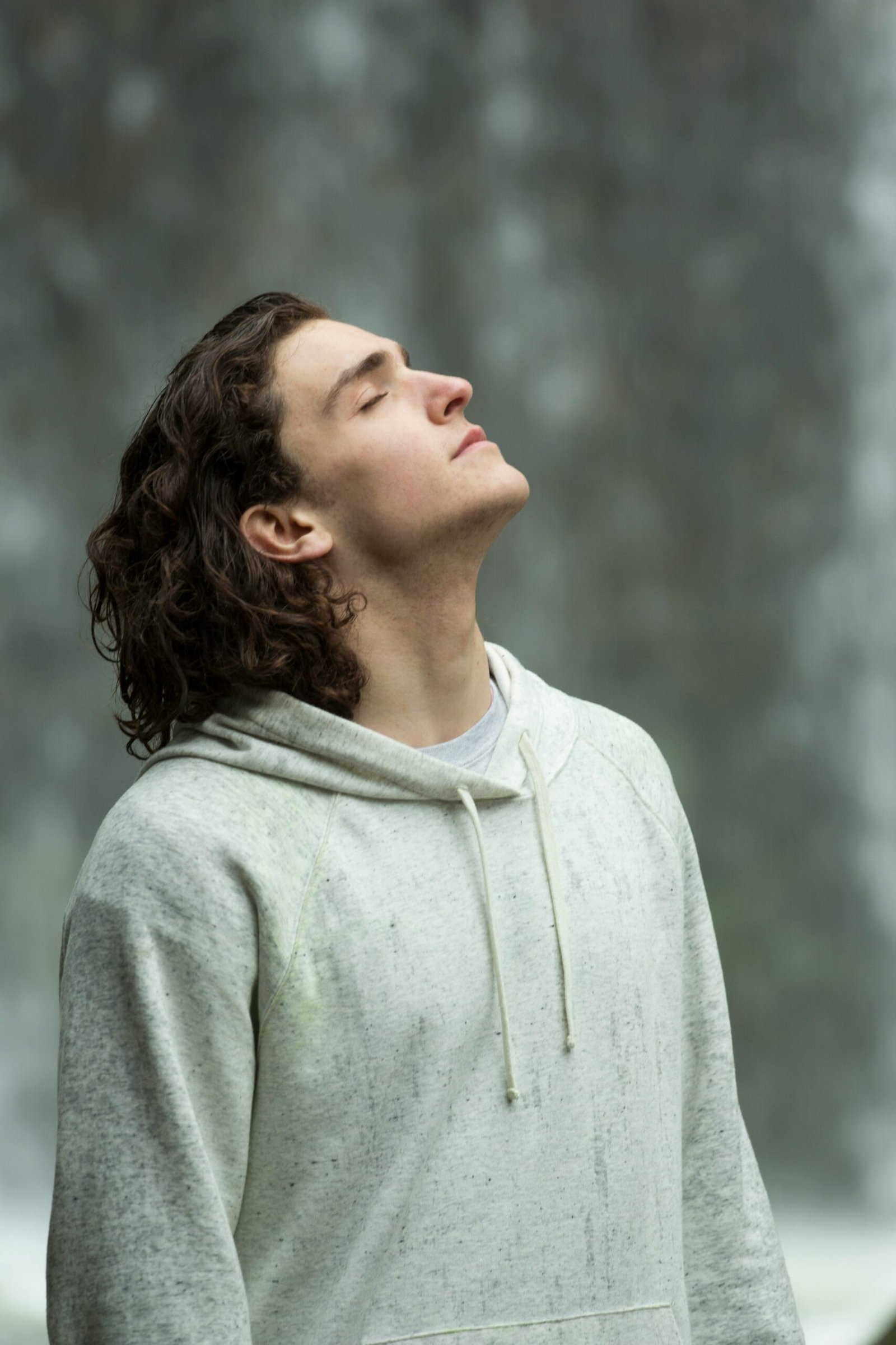 Man breathing with eyes closed in the open and under the rain